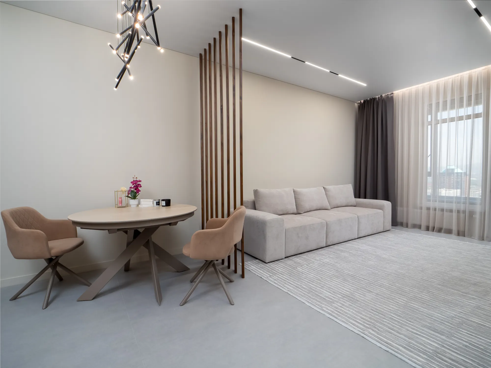 Open living room with round dining table and slatted screen