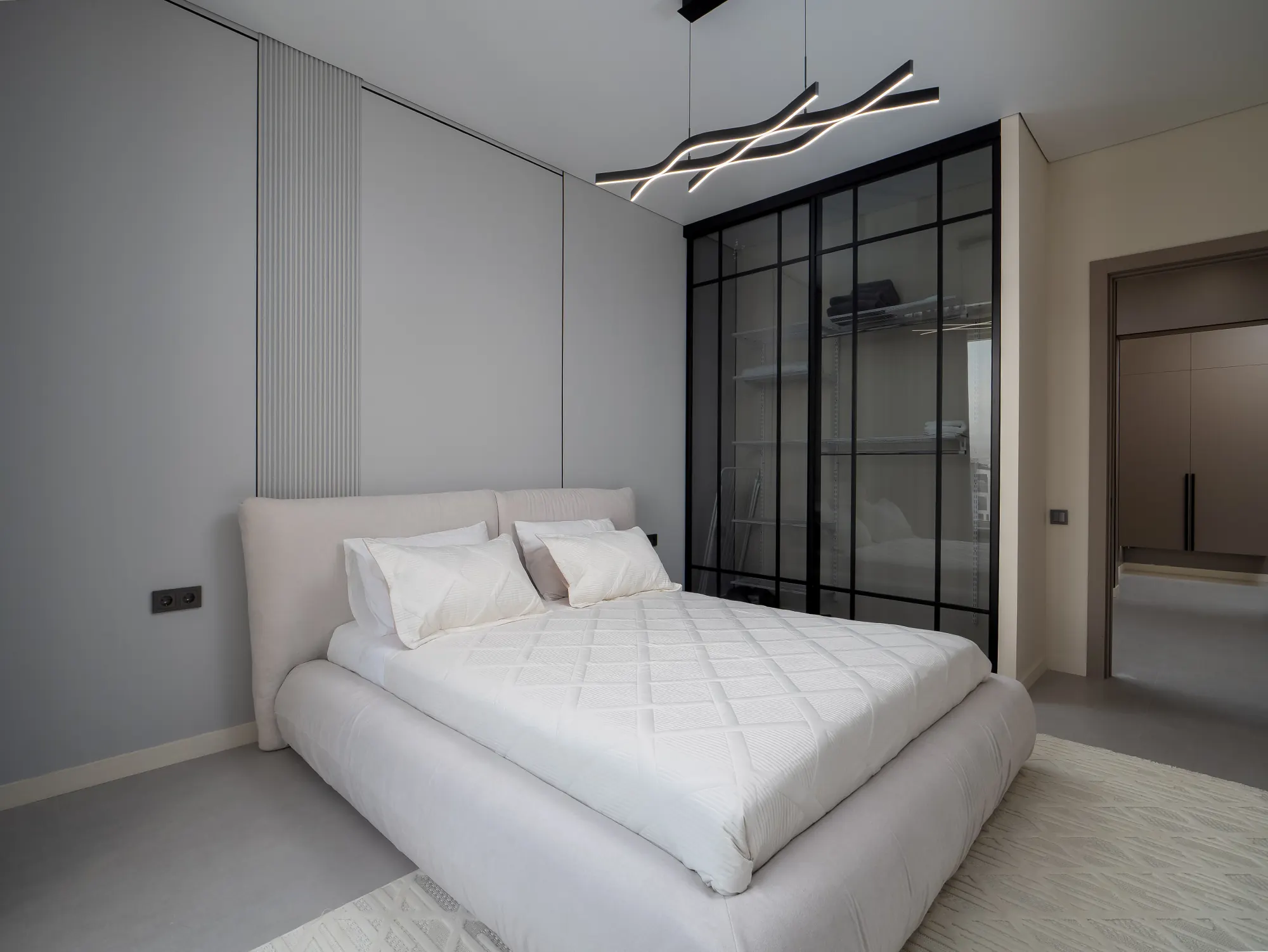 Bedroom behind a black-framed glass partition