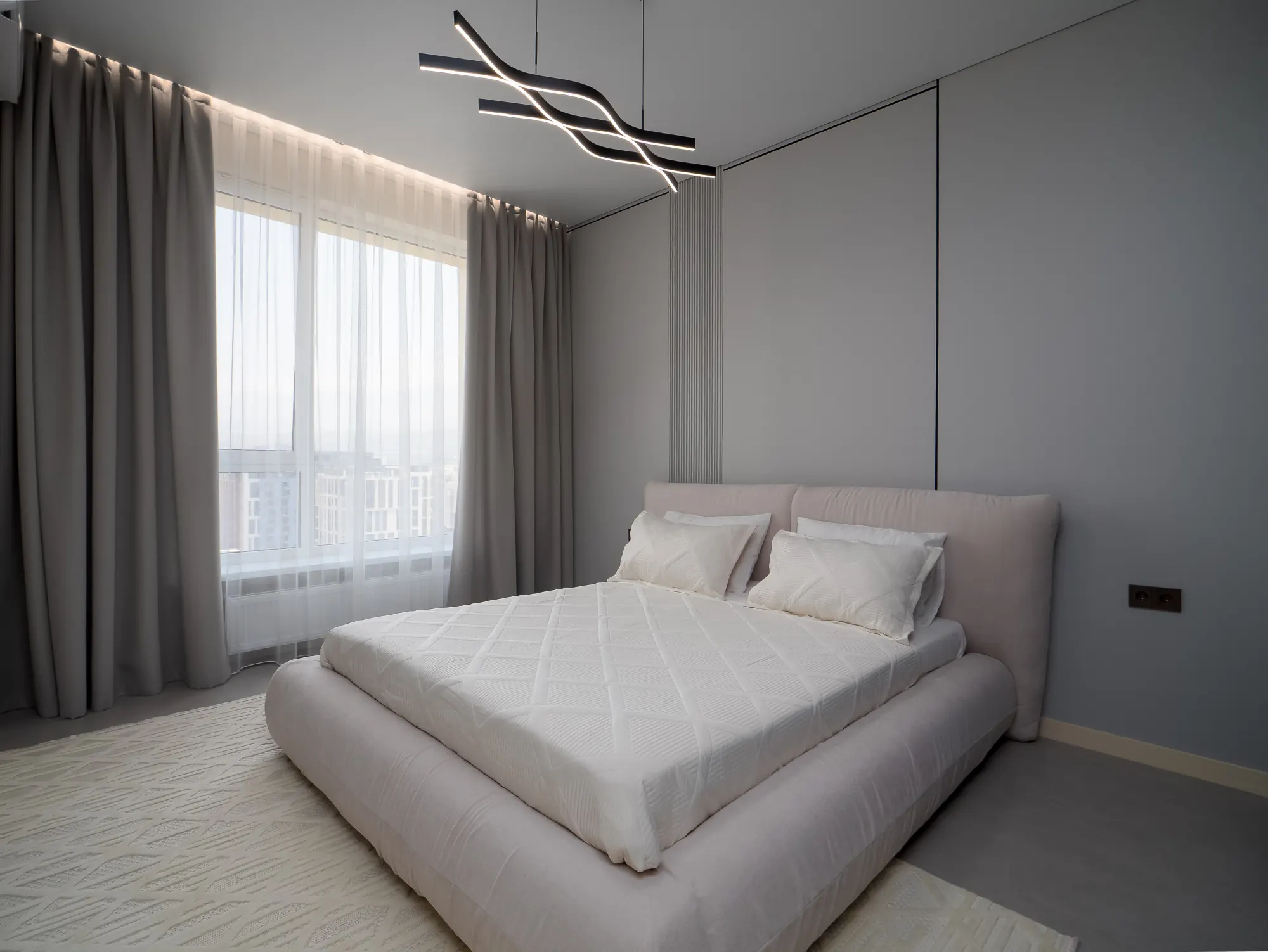 Wide bedroom view with full-height curtains