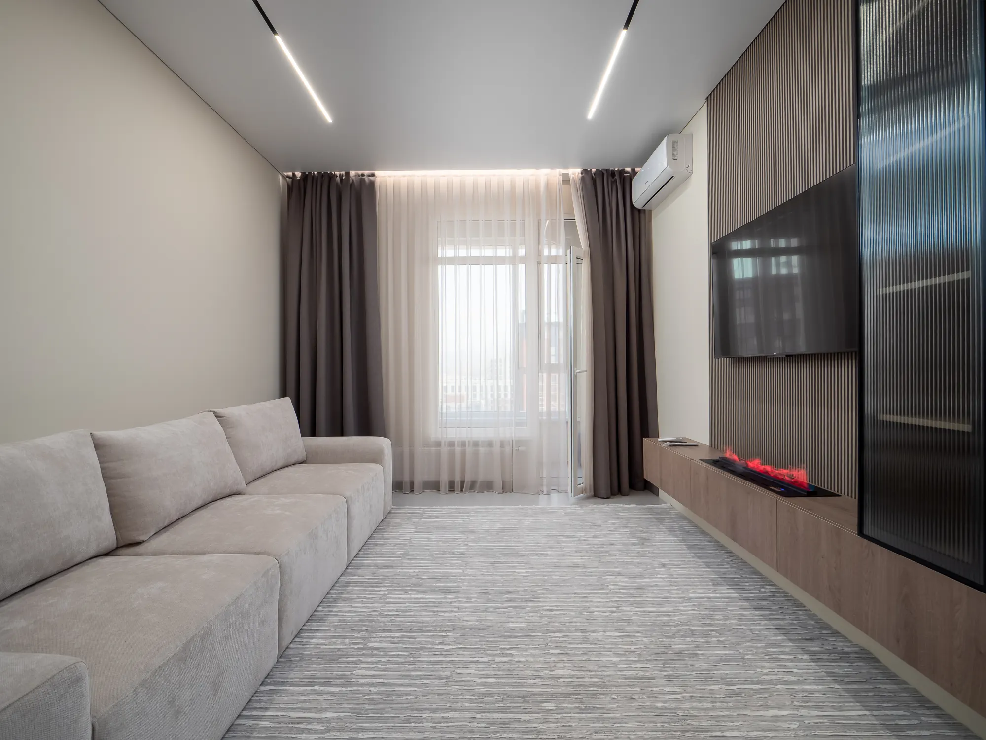 Living room with long sofa and media wall
