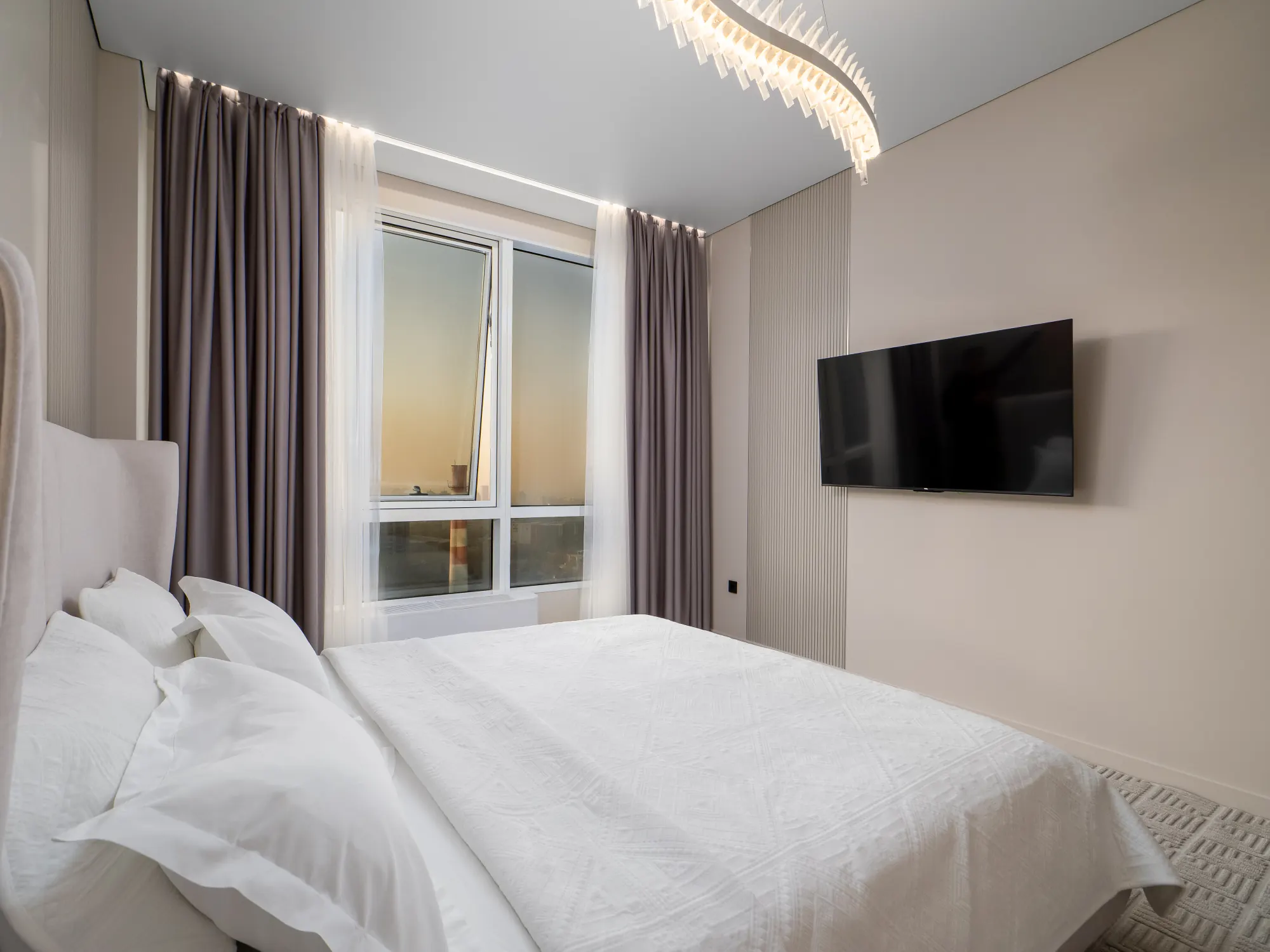 Bed facing the wall-mounted Smart TV